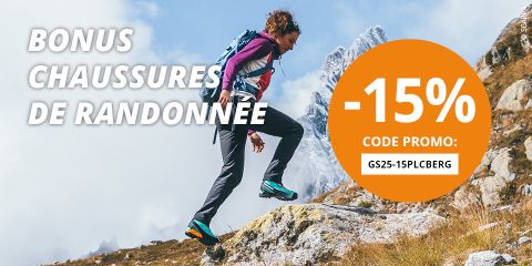 Une femme fait de la randonnée sur un sentier de montagne rocheux avec des sommets enneigés en arrière-plan. Le texte est le suivant : "Bonus chaussures de randonnée -15%. Code promo : GS25-15PLCBERG".