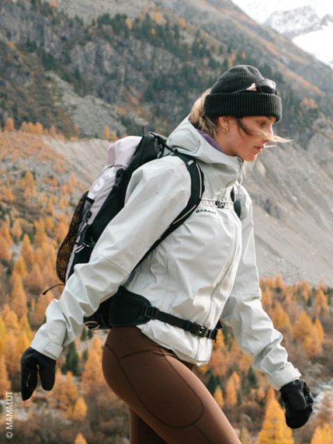 Une femme fait de la randonnée en automne dans la nature, vêtue d